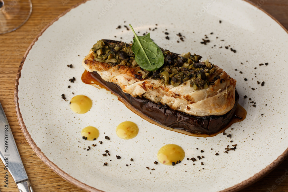 Baked eggplant stuffed with grilled chicken, tomatoes and spices on white plate. Traditional dish Karniyarik of turkish cuisine. View from above