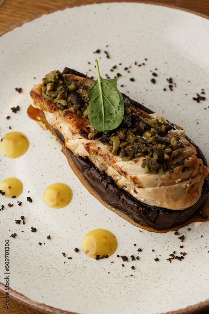 Baked eggplant stuffed with grilled chicken, tomatoes and spices on white plate. Traditional dish Karniyarik of turkish cuisine. View from above