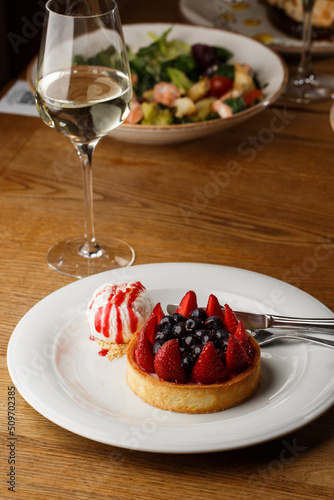 Obraz na płótnie Berry tartlets with curd cream on a wooden background. Summer fruit baking. Tartlets with raspberries, blueberries and red currants. Served with ice cream. w salonie