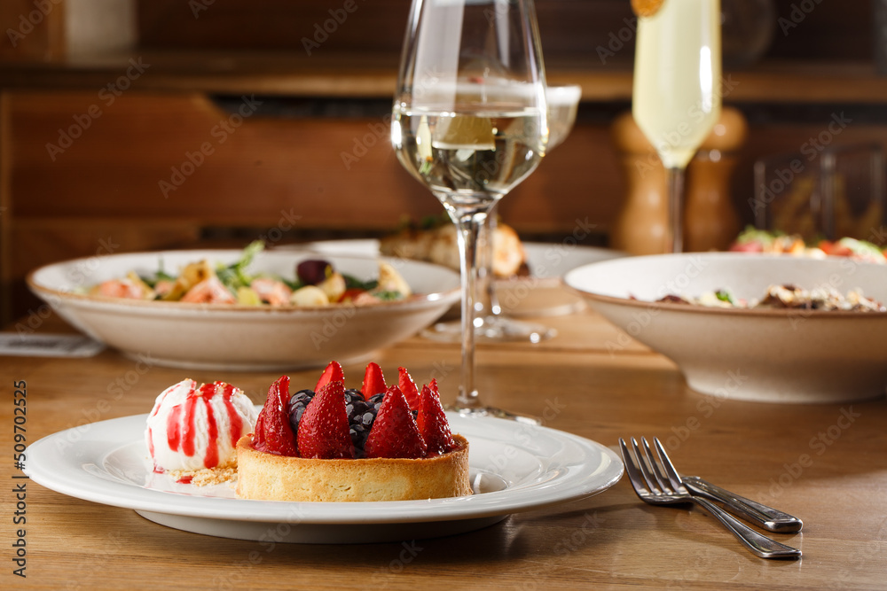 Berry tartlets with curd cream on a wooden background. Summer fruit baking. Tartlets with raspberries, blueberries and red currants. Served with ice cream.