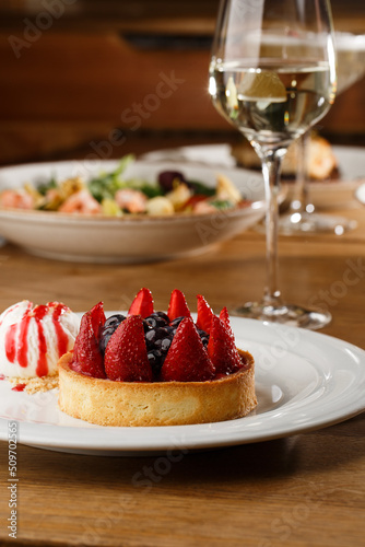 Obraz na płótnie Berry tartlets with curd cream on a wooden background. Summer fruit baking. Tartlets with raspberries, blueberries and red currants. Served with ice cream. w salonie