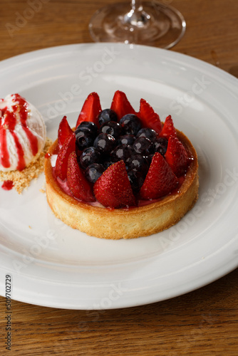 Obraz na płótnie Berry tartlets with curd cream on a wooden background. Summer fruit baking. Tartlets with raspberries, blueberries and red currants. Served with ice cream. w salonie