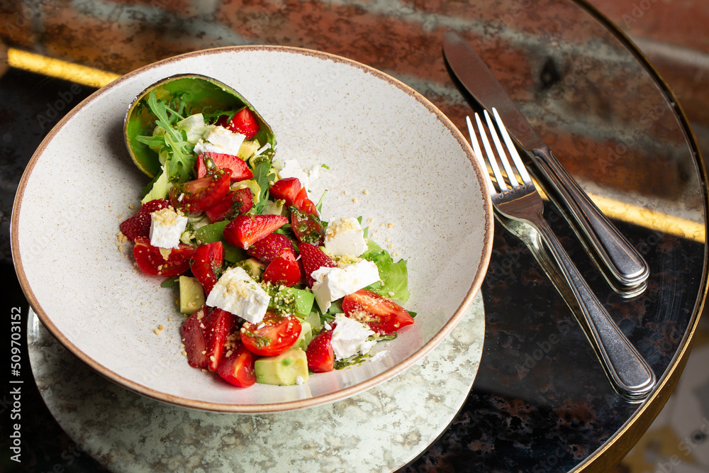 Tasty and healthy salad with arugula, brie cheese, avocado, cherry tomatoes and strawberry. Top view. The flat lay. Banner