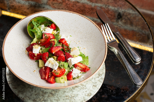 Obraz na płótnie Tasty and healthy salad with arugula, brie cheese, avocado, cherry tomatoes and strawberry. Top view. The flat lay. Banner w salonie