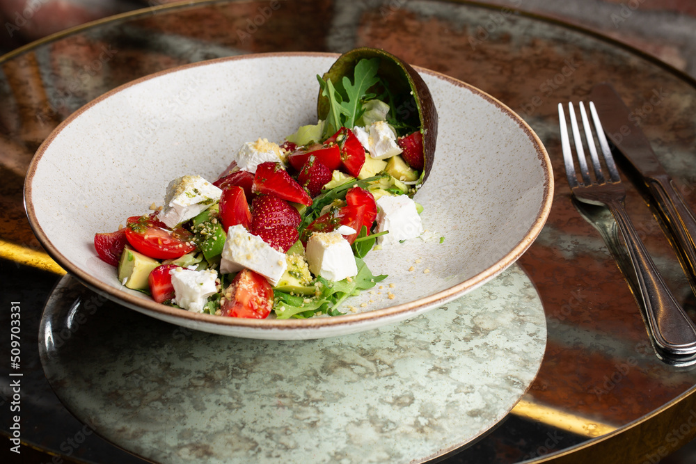 Tasty and healthy salad with arugula, brie cheese, avocado, cherry tomatoes and strawberry. Top view. The flat lay. Banner