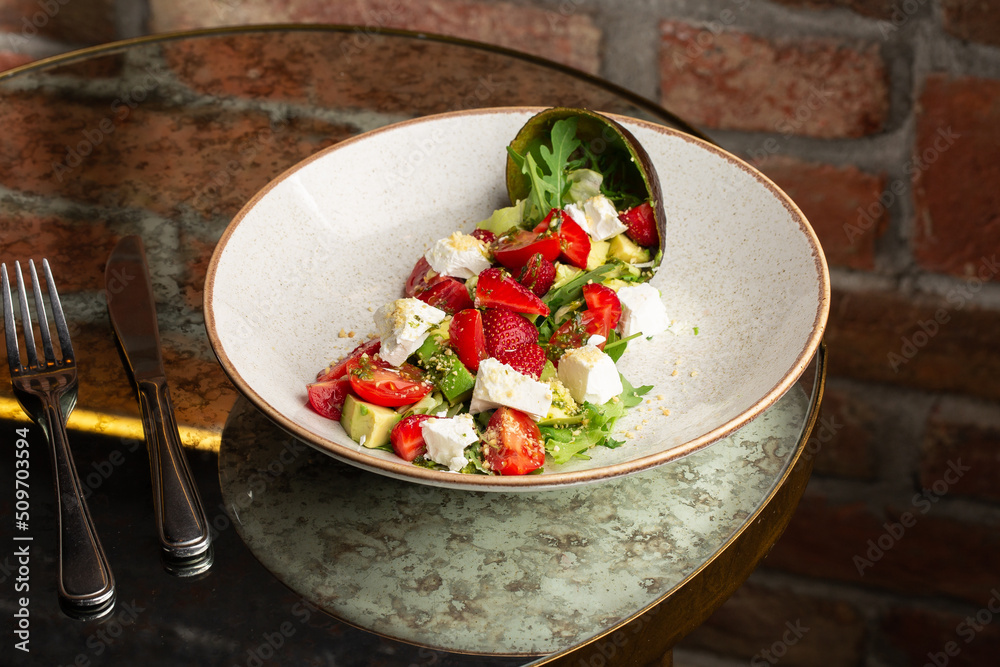 Tasty and healthy salad with arugula, brie cheese, avocado, cherry tomatoes and strawberry. Top view. The flat lay. Banner