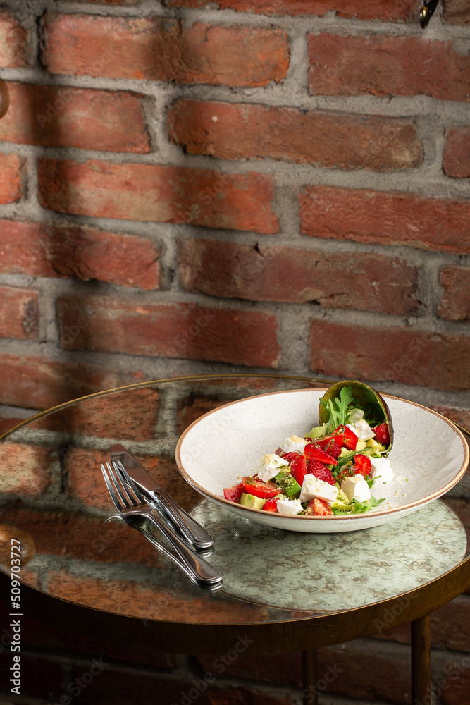 Tasty and healthy salad with arugula, brie cheese, avocado, cherry tomatoes and strawberry. Top view. The flat lay. Banner