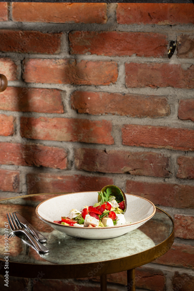 Tasty and healthy salad with arugula, brie cheese, avocado, cherry tomatoes and strawberry. Top view. The flat lay. Banner