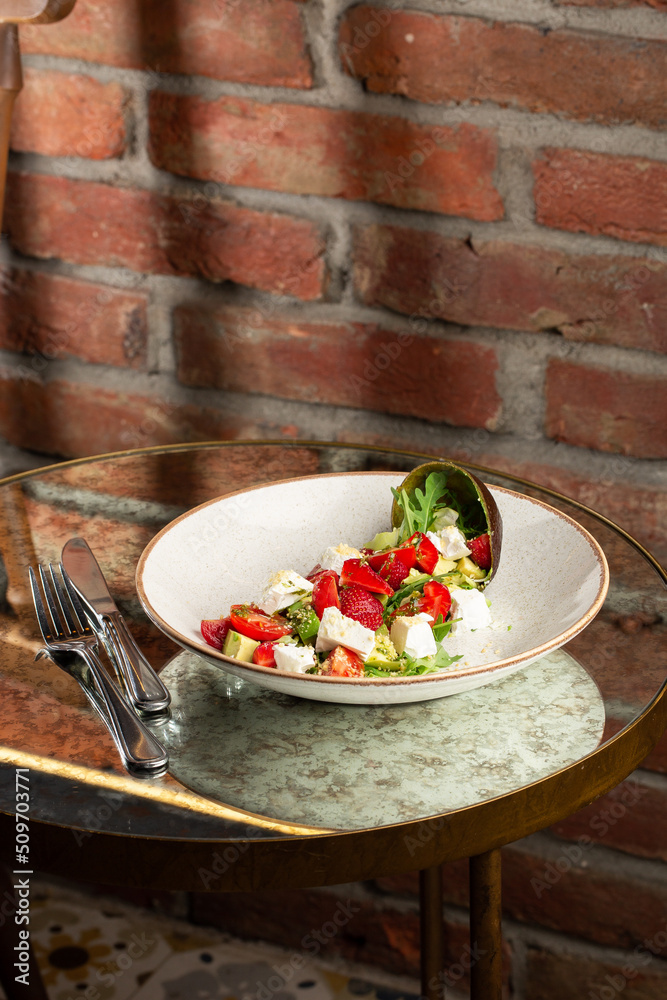 Tasty and healthy salad with arugula, brie cheese, avocado, cherry tomatoes and strawberry. Top view. The flat lay. Banner