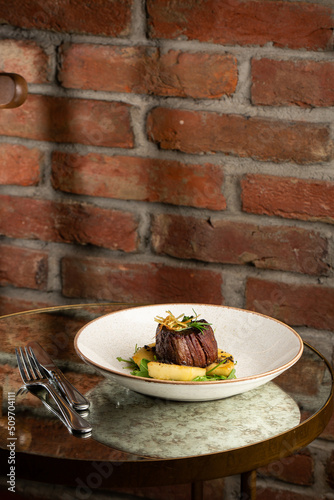Obraz na płótnie Grilled meat fillet steak medallion with green sauce, served with pear or apple. On dark background w salonie