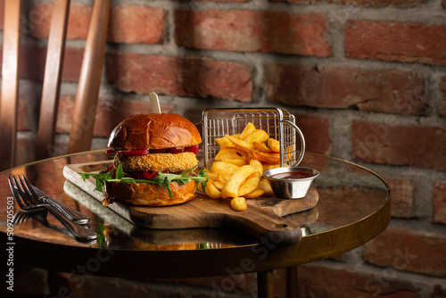 Obraz na płótnie Big cheeseburger with french fries. Hamburger with beef patty onion, tomato, lettuce pickles, melted cheddar, mustards, tomato jam, mayo w salonie