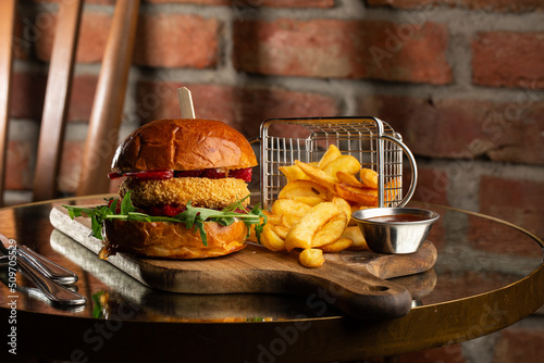 Obraz na płótnie Big cheeseburger with french fries. Hamburger with beef patty onion, tomato, lettuce pickles, melted cheddar, mustards, tomato jam, mayo w salonie