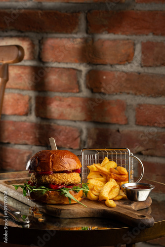Obraz na płótnie Big cheeseburger with french fries. Hamburger with beef patty onion, tomato, lettuce pickles, melted cheddar, mustards, tomato jam, mayo w salonie