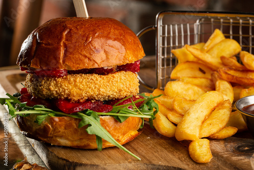 Obraz na płótnie Big cheeseburger with french fries. Hamburger with beef patty onion, tomato, lettuce pickles, melted cheddar, mustards, tomato jam, mayo w salonie