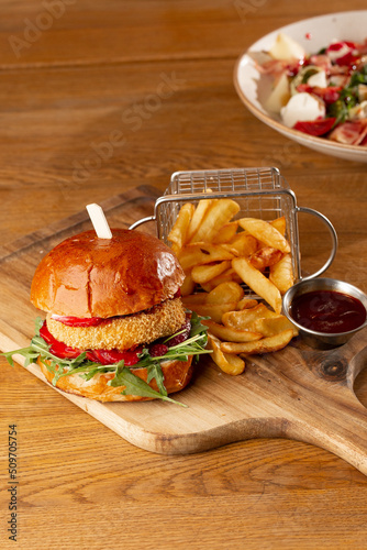 Obraz na płótnie Big cheeseburger with french fries. Hamburger with beef patty onion, tomato, lettuce pickles, melted cheddar, mustards, tomato jam, mayo w salonie
