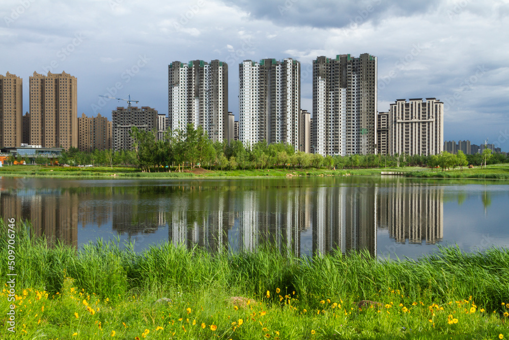 Modern apartment building by a city park in summer. Changchun, Jilin, China.
