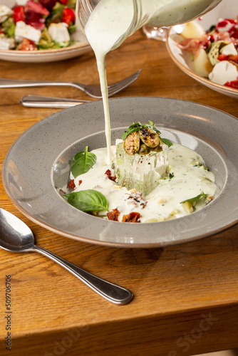 Obraz na płótnie Closeup of cold soup okroshka with beef, vegetables and kefir served in a white bowl, selective focus. Summer, cold soup with cucumber, radish, egg, potatoes and fresh herbs seasoned with kefir. w salonie