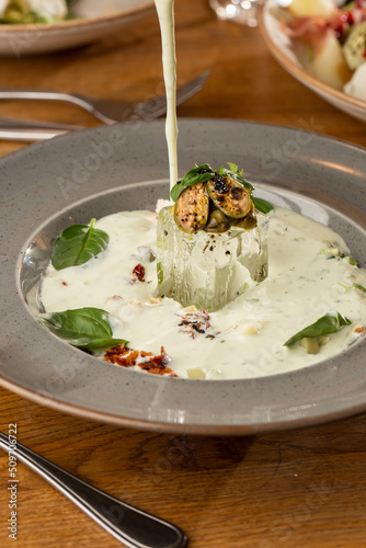 Obraz na płótnie Closeup of cold soup okroshka with beef, vegetables and kefir served in a white bowl, selective focus. Summer, cold soup with cucumber, radish, egg, potatoes and fresh herbs seasoned with kefir. w salonie