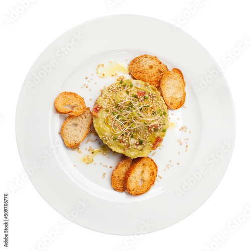 Raw salmon tartare with guacamole, microgreens and sesame seeds served with toasted bread. Isolated on white background