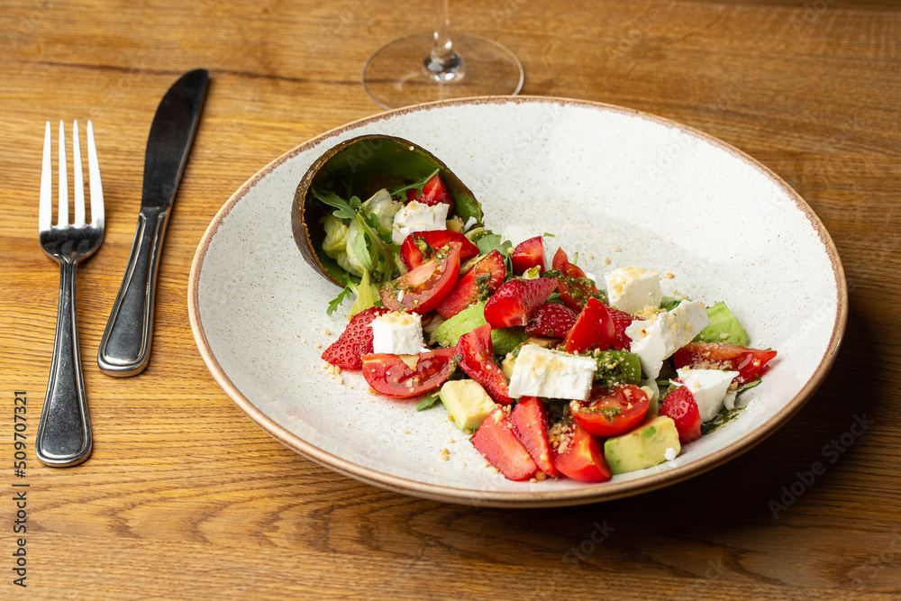 Tasty and healthy salad with arugula, brie cheese, avocado, cherry tomatoes and strawberry. Top view. The flat lay. Banner