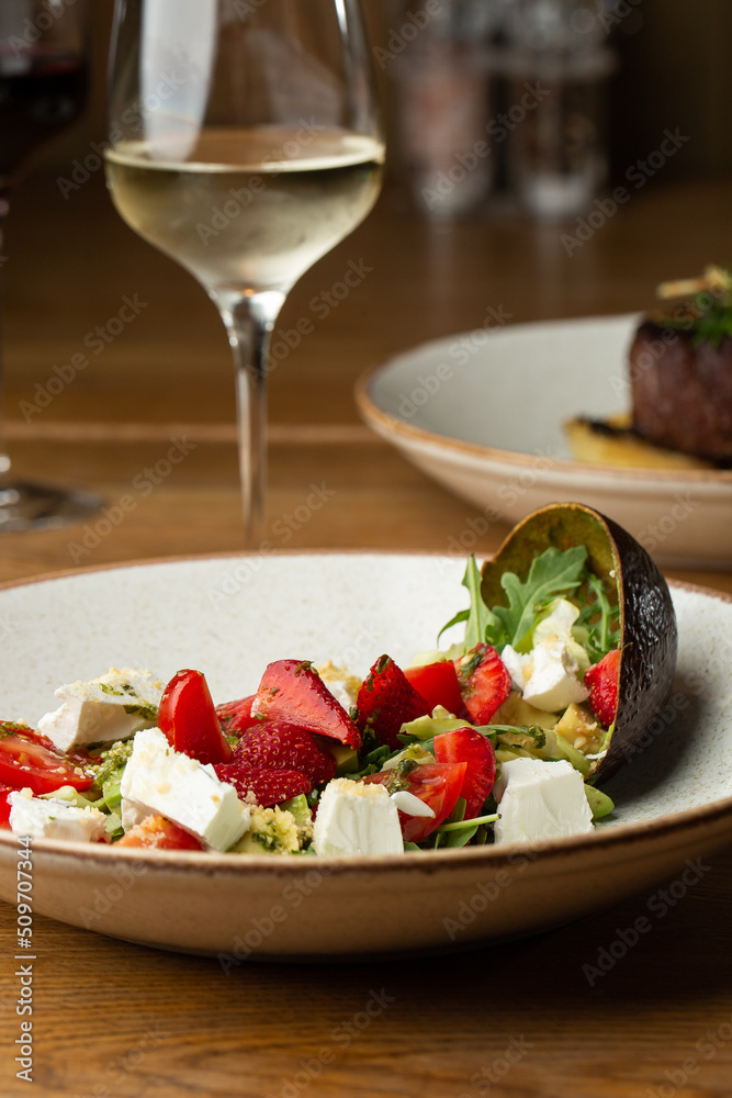 Tasty and healthy salad with arugula, brie cheese, avocado, cherry tomatoes and strawberry. Top view. The flat lay. Banner