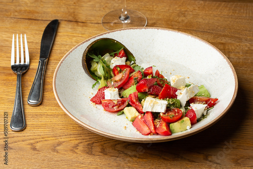 Obraz na płótnie Tasty and healthy salad with arugula, brie cheese, avocado, cherry tomatoes and strawberry. Top view. The flat lay. Banner w salonie