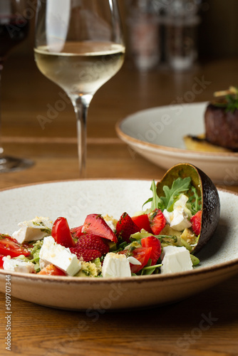 Obraz na płótnie Tasty and healthy salad with arugula, brie cheese, avocado, cherry tomatoes and strawberry. Top view. The flat lay. Banner w salonie