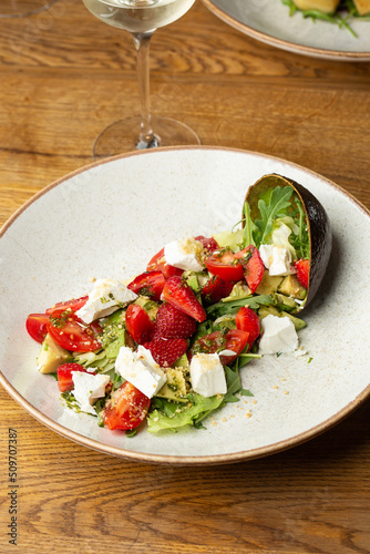 Obraz na płótnie Tasty and healthy salad with arugula, brie cheese, avocado, cherry tomatoes and strawberry. Top view. The flat lay. Banner w salonie