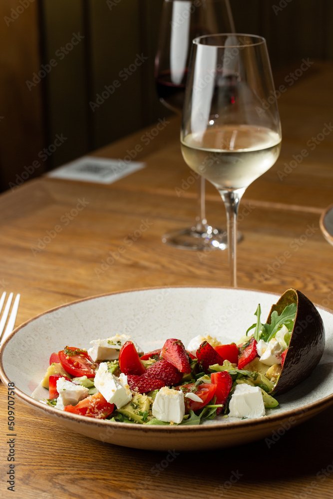 Tasty and healthy salad with arugula, brie cheese, avocado, cherry tomatoes and strawberry. Top view. The flat lay. Banner