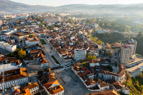 Picturesque drone view of Vila Real cityscape in valley framed by Serra do Alvao and Serras do Marao mountains in light fog on sunny spring day, Portugal photo