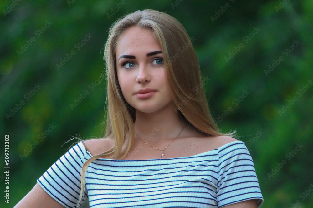 Fototapeta premium beautiful fashionable blond girl in the city on the park in dress