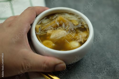 Fish maw soup (quail eggs, bamboo shoot, rice vermicelli and chicken) in mini bowl. photo