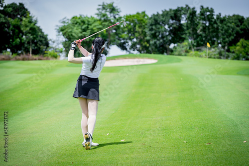 Professional woman golfer teeing golf in golf tournament competition at golf course for winner 