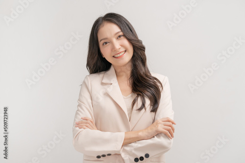 Smiling positive, attractive asian young woman, girl in beige suit formal dress, portrait elegant of pretty with long black hair, feeling happy looking at camera standing isolated on white background.
