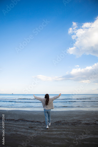 Young woman from behind is running at the beach to the sea in Larnaca  Cyprus
