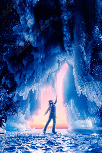 Tourist man in Ice blue cave or grotto on frozen lake Baikal. Concept beautiful adventure travel winter landscape with people