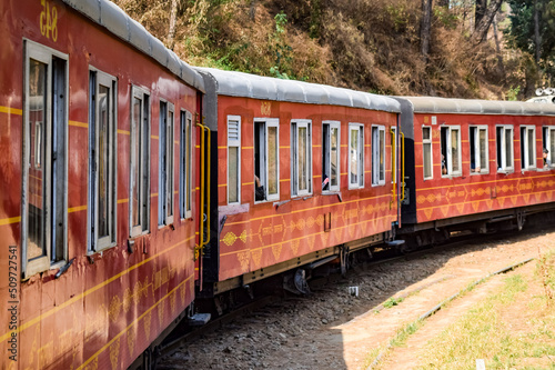 Toy Train moving on mountain slopes, beautiful view, one side mountain, one side valley moving on railway to the hill, among green natural forest. Toy train from Kalka to Shimla in India