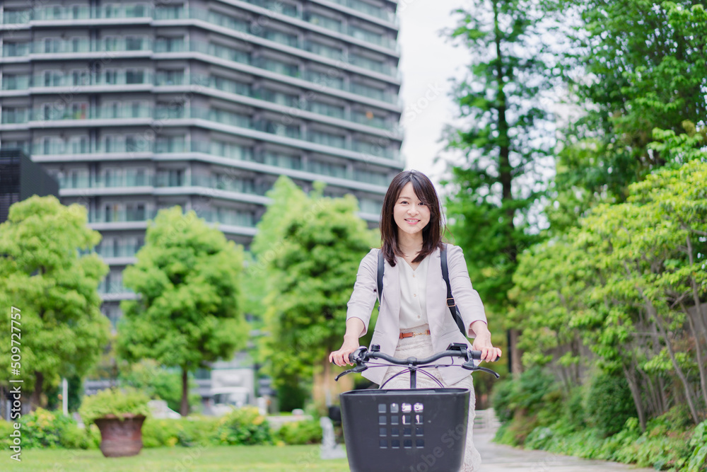 シェアサイクルで通勤をするビジネスウーマン シェアサイクルで通勤をするビジネスウーマン