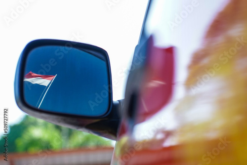 The Indonesian flag as seen in the rear view mirror.