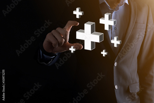 Businessman hold 3D plus icon, man hold in hand offer positive thing such as profit, benefits, development, CSR represented by plus sign.The hand shows the plus sign