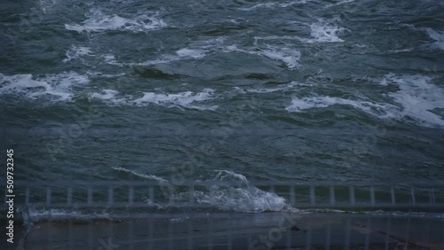 Rapid flow of river waters. Spring melt water boils and foams in the river. Static view.