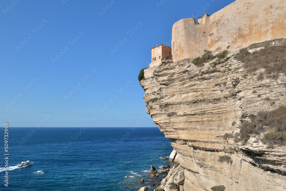 rampart above limestone cliff fo city Bonifacio in Corsica overlooking the sea on clear blue sky