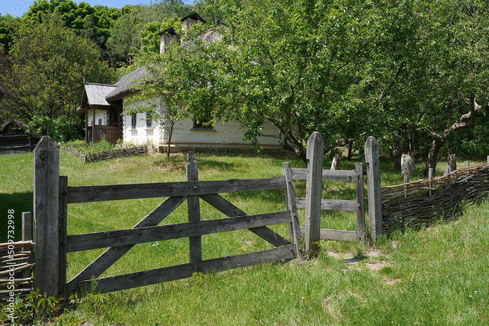 old wooden fence in front of a vintage log house