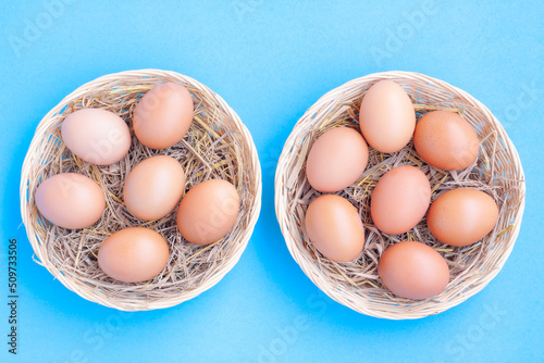 Bild auf Leinwand Chicken Eggs in a basket on blue with grain background