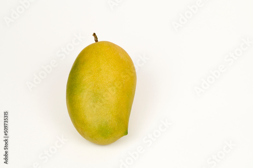 Closeup view of single Kesar Mango on a white background
