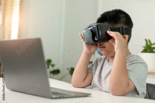 schoolboy wearing vr glasses in classroom. unaltered, education, virtual reality simulator, technology and school concept. © FAMILY STOCK