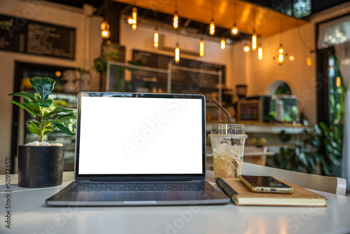 Obraz na płótnie Mockup of laptop computer with empty screen with notebook,ice coffee and smartphone on table side the window in the coffee shop at the cafe,White screen w salonie