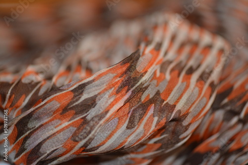 Orange, red and brown colored scarf texture. Macro photo