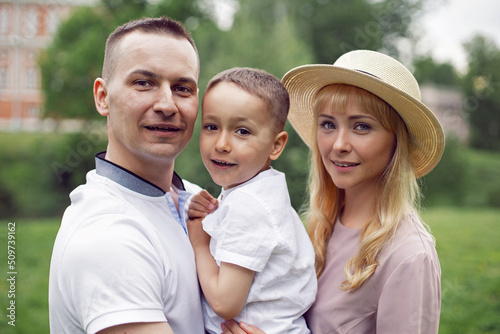 portrait family with a child a boy of 4 years old stand on green field in summer