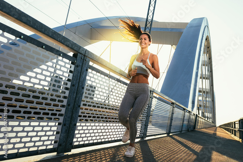 Female runner jogging in the city on the bridge